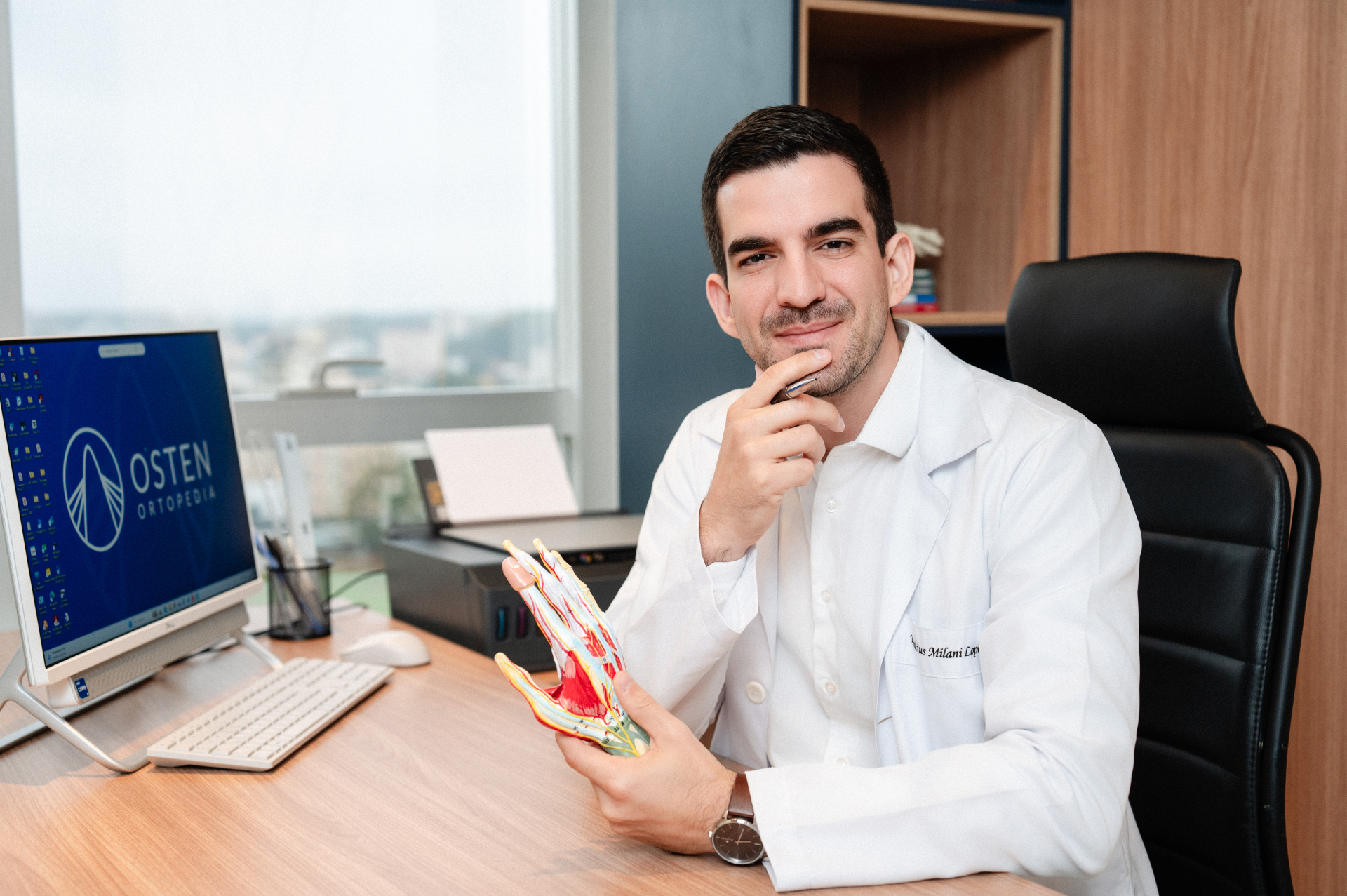 Dr. Vinícius Milani com modelo anatômico da mão
