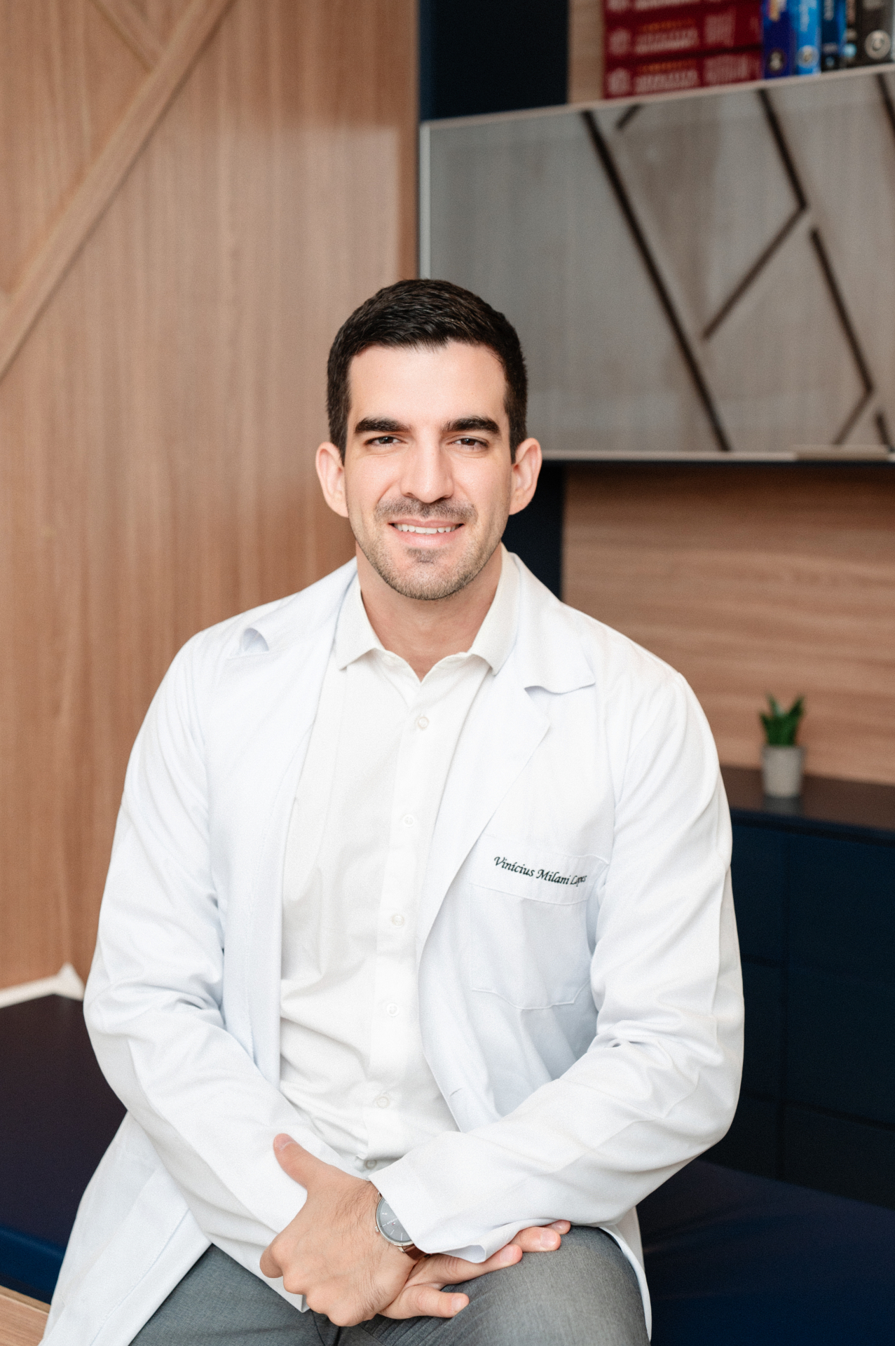 Dr. Vinícius Milani sorrindo no consultório